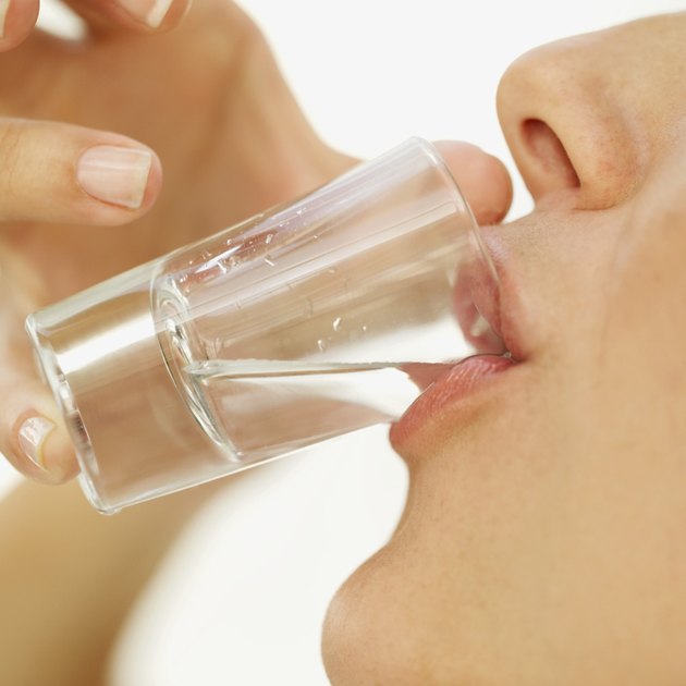 close-up of a young woman drinking a shot of tequila