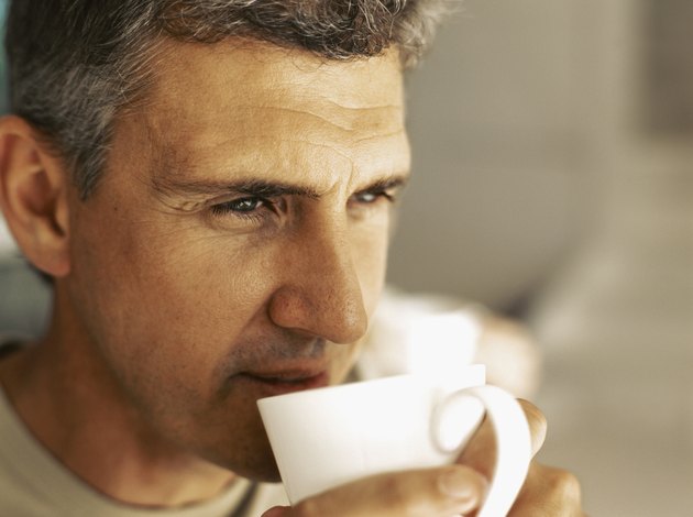 close-up of a mature man drinking a cup of tea
