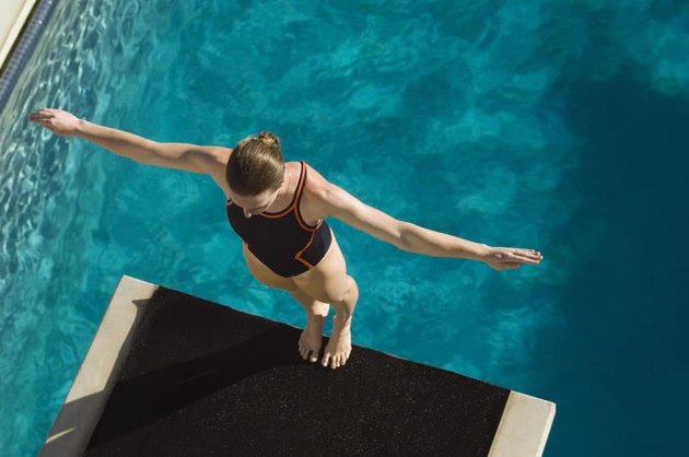 Female swimmer standing on diving board