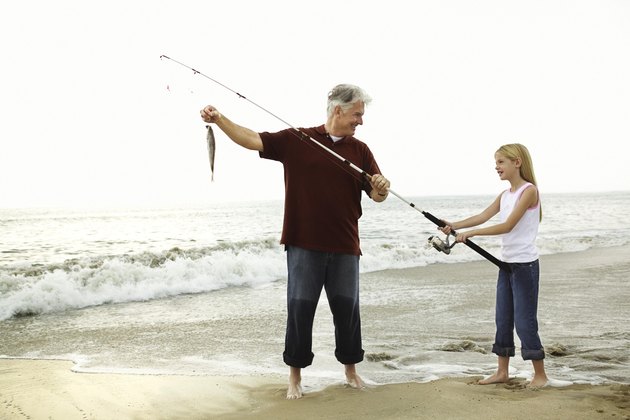 Father and daughter fishing on beach