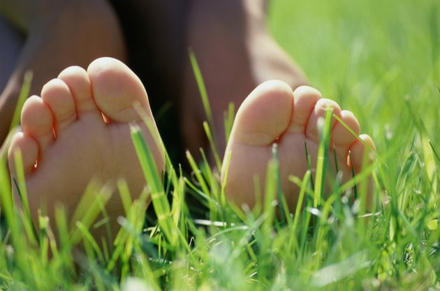 Close-up of the sole of a person's feet lying on grass