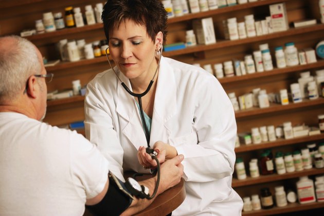 Doctor takes an older patients blood pressure