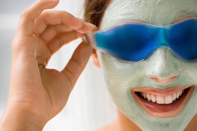 Smiling woman with facial mask and gel eyemask