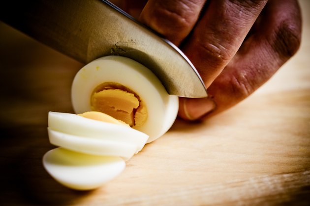 Close-up of cook slicing hard-boiled egg