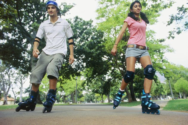 Low angle view of a young couple inline skating in a park