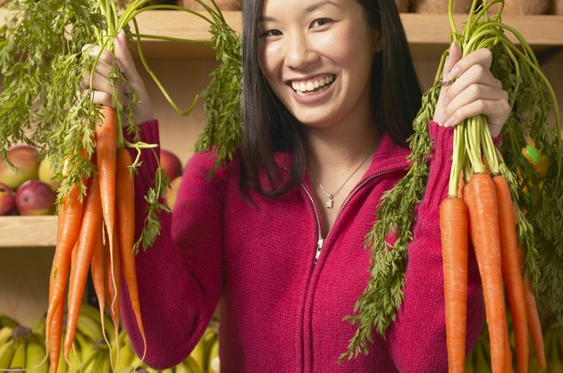 一位年轻女子的肖像笑着抓蔬菜