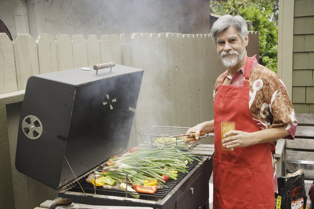 Middle-aged man grilling vegetables