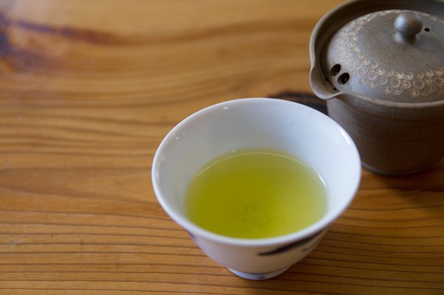 Japanese green tea in porcelain cup and tea pot.