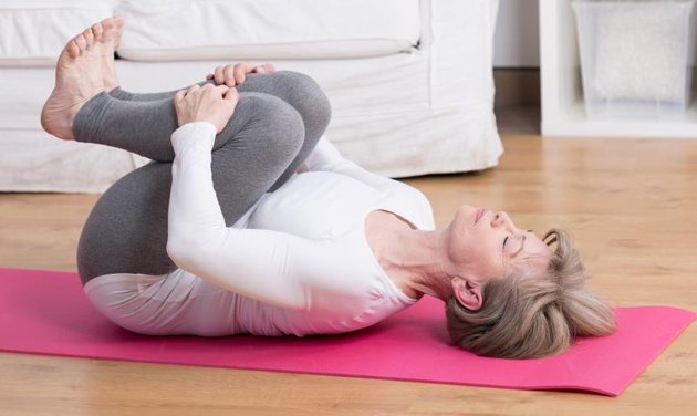 Beauty mature woman practicing pilates at home