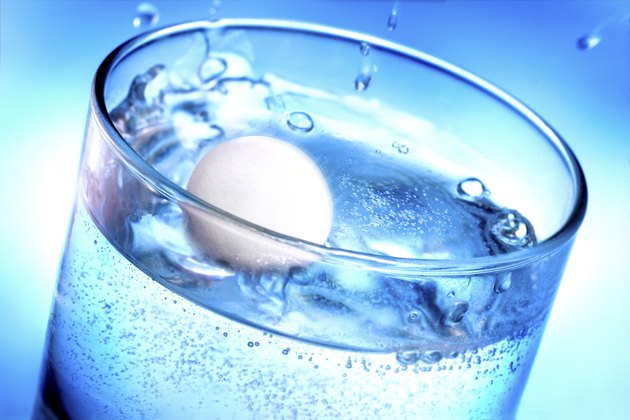 Medicine pill tablet splashing into glass