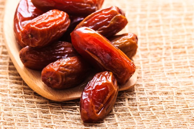 dried dates on wooden spoon cloth background
