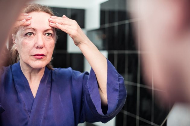 Mature Woman putting cream on her face