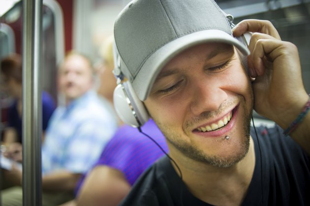 Man with headphones rocking out during subway commute