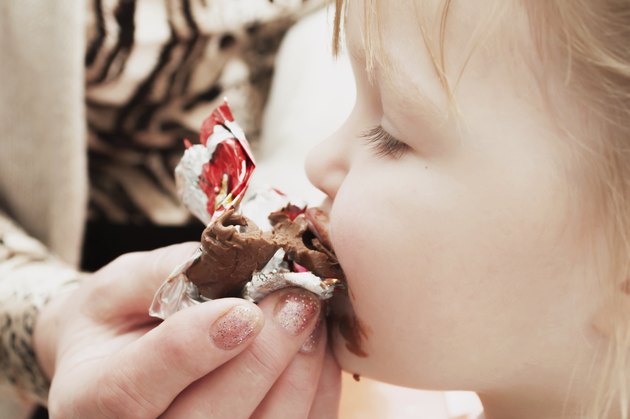 little girl eating chocolate candy. Pleasure.