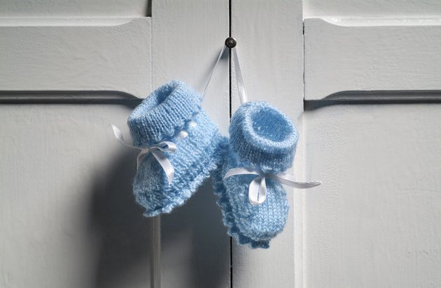 Blue Baby Booties hanging on white door