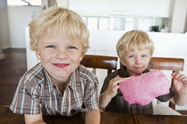 Twin boys sharing cotton candy