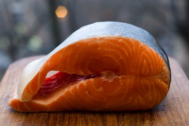 Fresh salmon fish on wooden cooking desk