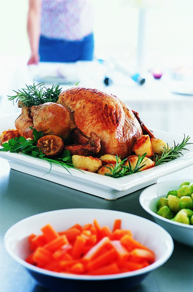 Roast Turkey and Vegetables with a Woman in the Background