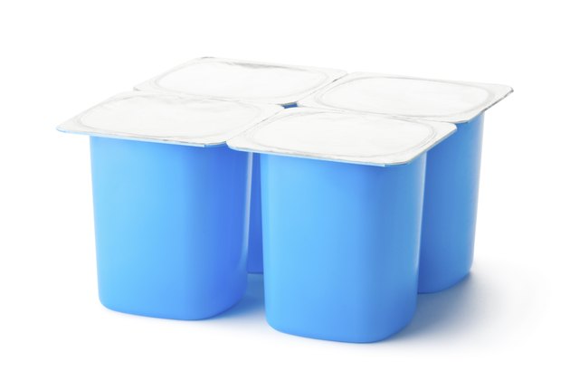 Four plastic containers for dairy products with foil lid