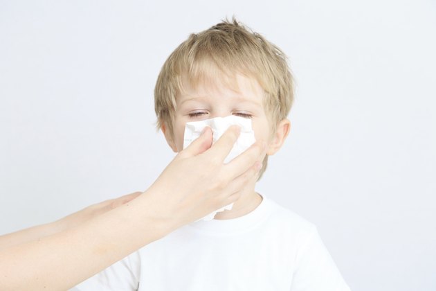 child blowing his nose