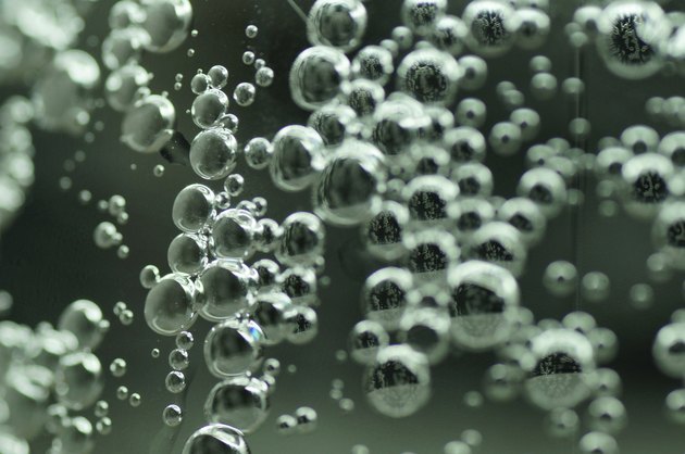 Close up sparkling bubble water, green bottle