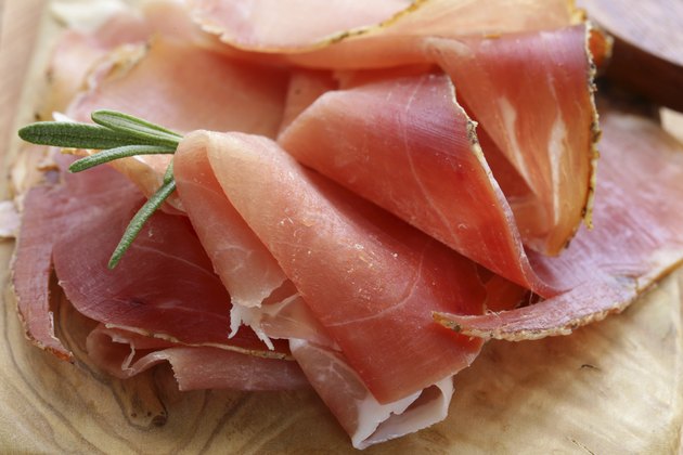 parma ham (jamon) sliced on a wooden board