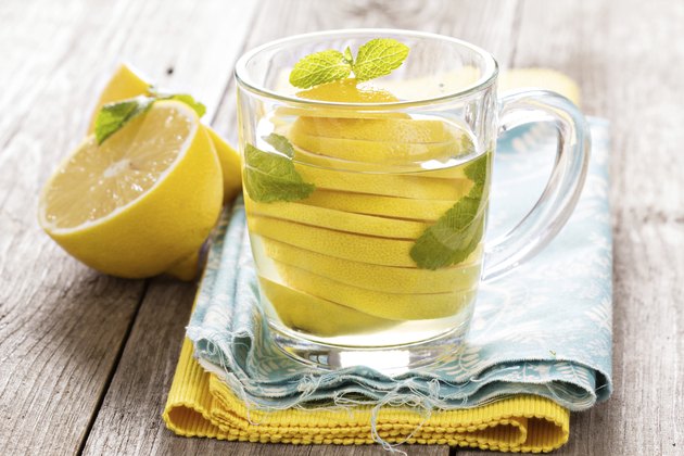 Tea with mint and whole lemon in a transparent cup