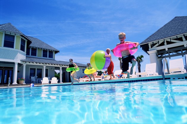 Children jumping into swimming pool