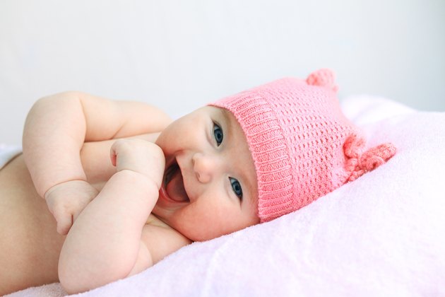 laughing baby girl in pink hat