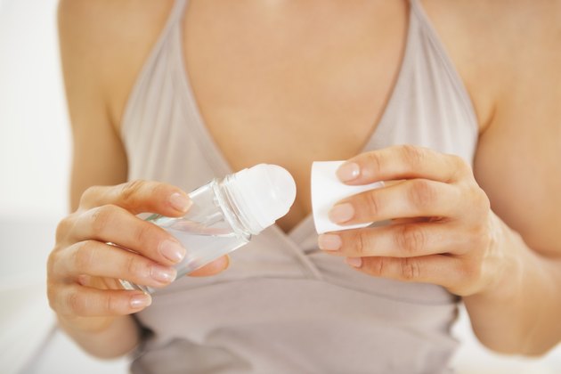 closeup on young woman using deodorant