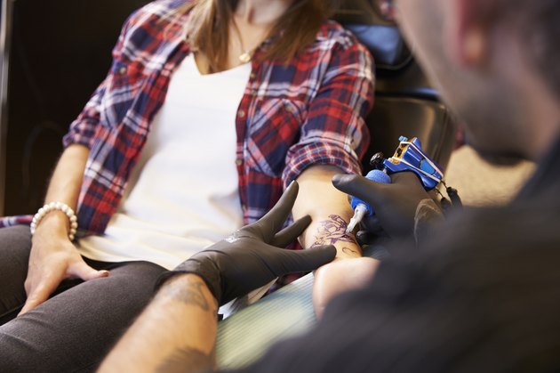 Close Up Of Woman Sitting In Chair Having Tattoo