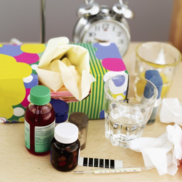 table with bottle of medicine and a box of tissues