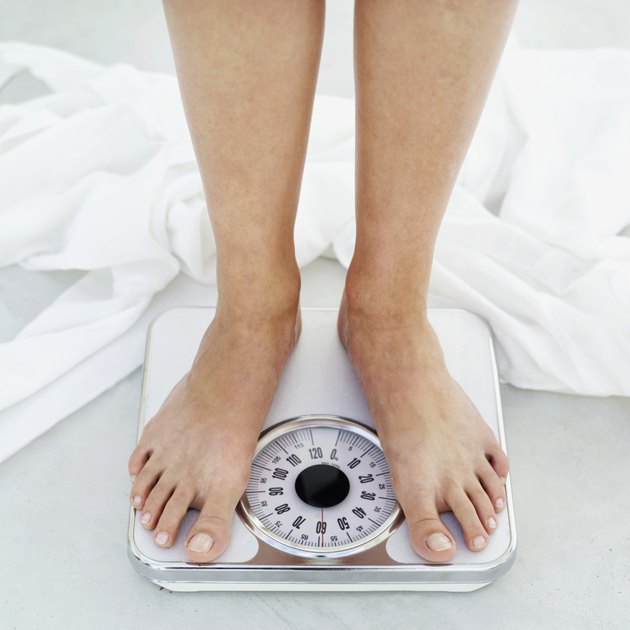 low section view of a person standing on a bathroom scale