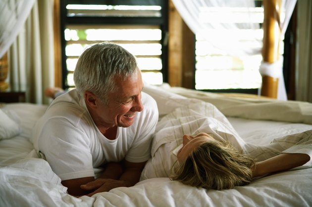 Senior couple smiling at each other in bed, close-up