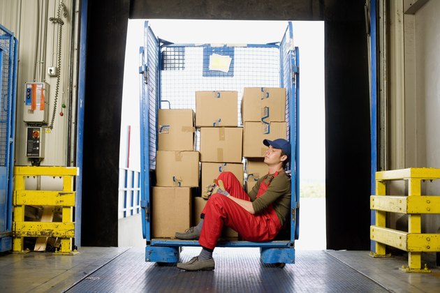 Worker sitting on loading dock with boxes