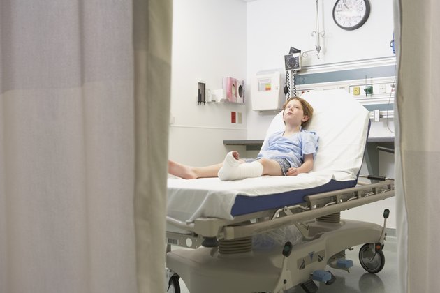 Young boy with broken leg laying in hospital bed