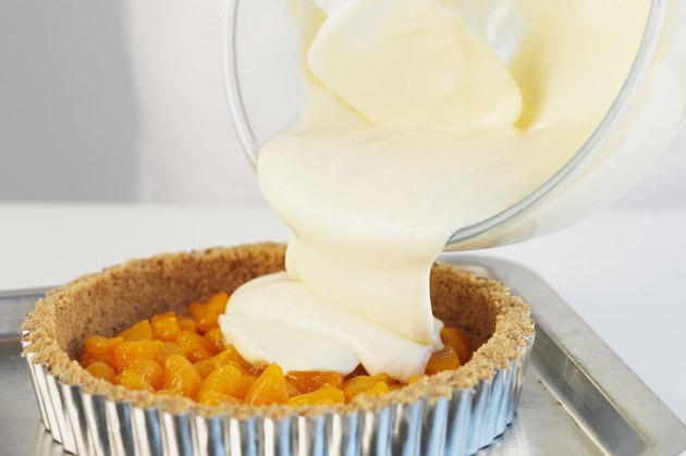Pouring cheesecake mixture onto orange, close up