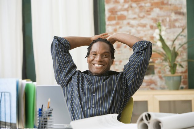 African businessman with hands behind head