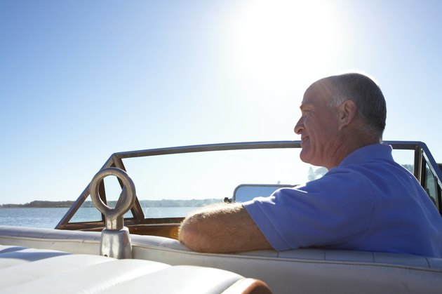 Mature man sitting on boat, side view