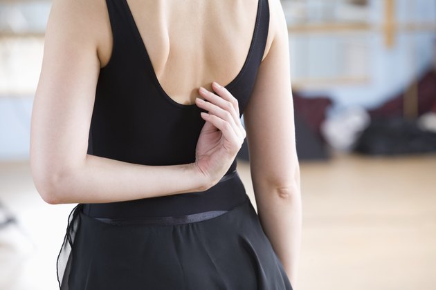Young woman stretches in ballet rehearsal