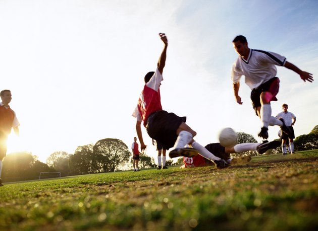 Soccer players tackling for ball, ground view
