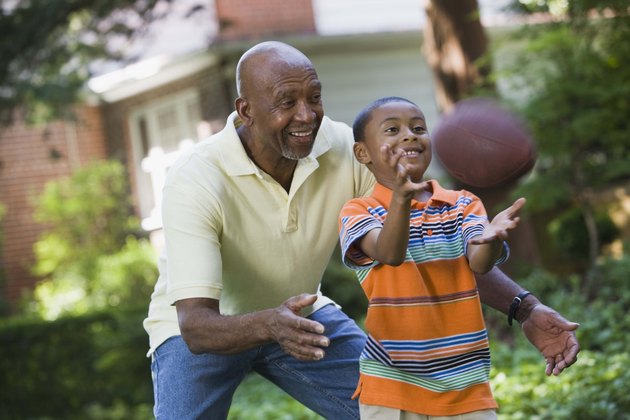 Grandfather and grandson playing football