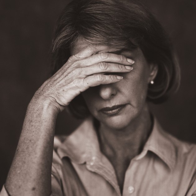 close-up of sad young woman with her hand covering her eyes