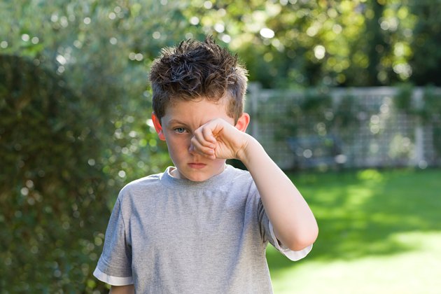 Boy rubbing eye
