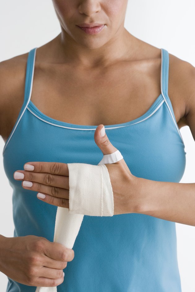 Mid section of woman wrapping hand