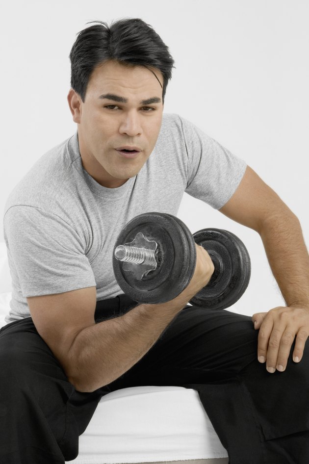 Man sitting and holding dumbbell