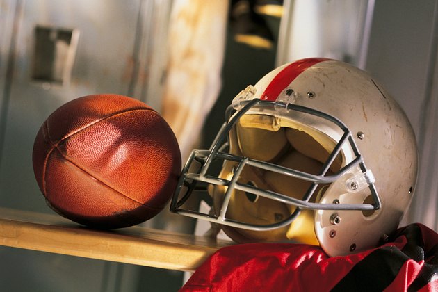 Football and helmet with jersey on locker room bench
