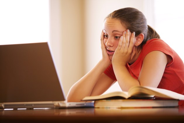 Teenage girl with laptop doing homework