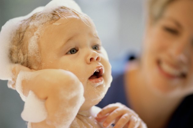 Close-up of a baby boy getting a bath from his mother