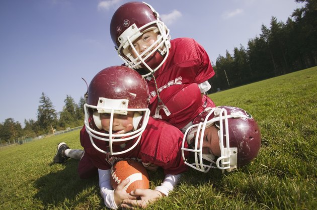 Three kids playing football